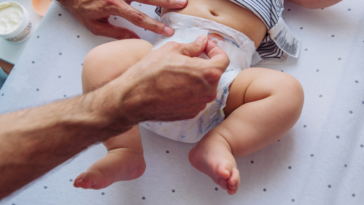 A man changing a baby's diaper.