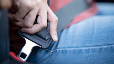 A man fastening his seatbelt.