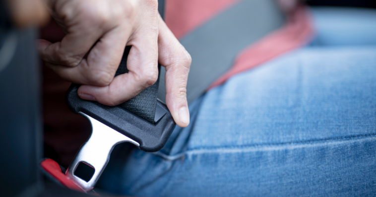 A man fastening his seatbelt.