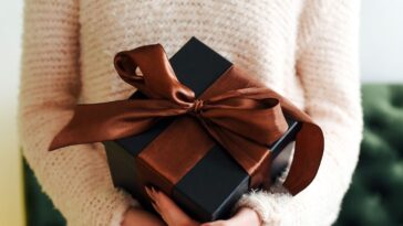 Brown gift box in female hands.