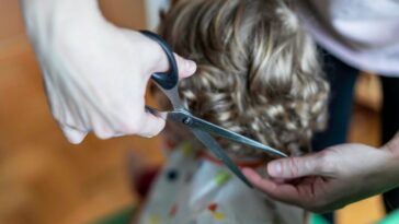Close-up shot of a young child's hair being cut.