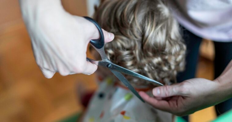Close-up shot of a young child's hair being cut.