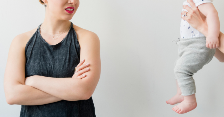 Woman appearing disgusted when asked to hold a baby
