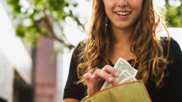 Teen removing money from a wallet.