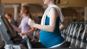 A pregnant woman on a treadmill.