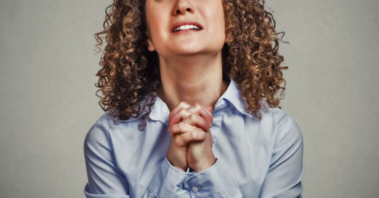 Woman clasping hands together and begging
