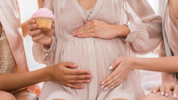 Pregnant woman holding cupcake