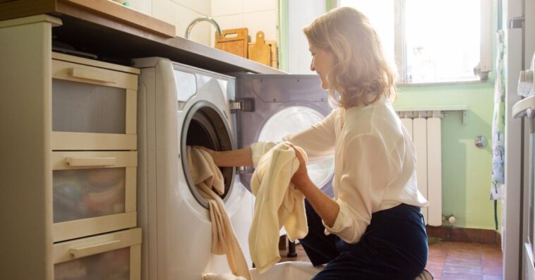 Woman putting cashmere sweaters in the washing machine