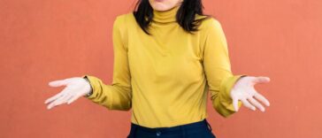 Woman in yellow turtleneck shrugging