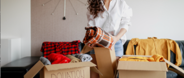 A woman going through boxes of clothes.
