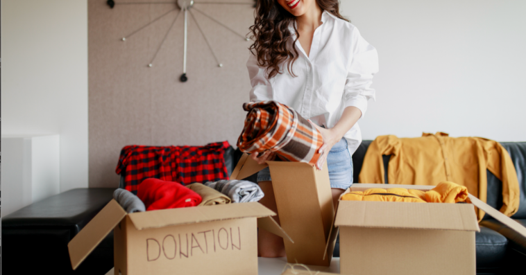 A woman going through boxes of clothes.