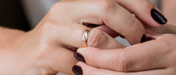 woman adjusts gold wedding band on her finger