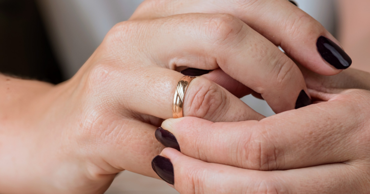 woman adjusts gold wedding band on her finger