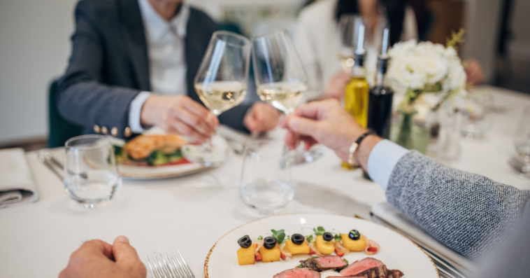 group makes toast at small dinner