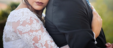 bride hugs her groom from behind