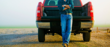 man leans against tailgate of truck