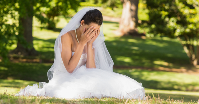 upset bride seated on the grass