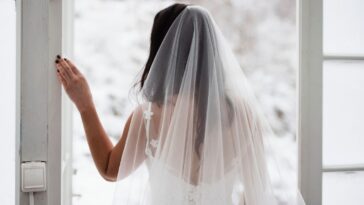 Back shot of a bride looking out the window.