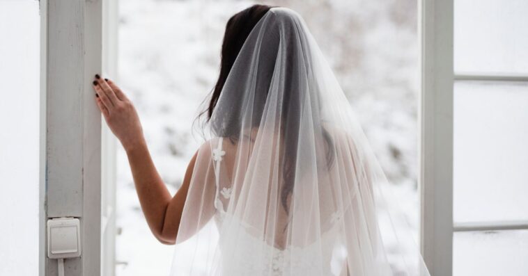 Back shot of a bride looking out the window.