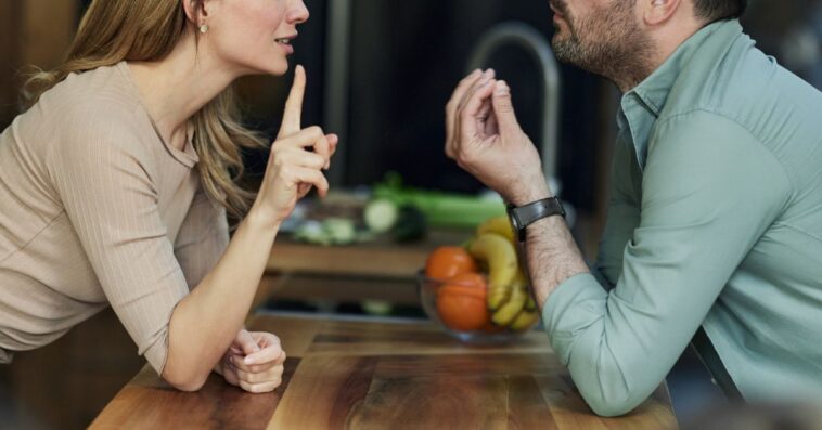 Frustrated couple having an argument in the kitchen.
