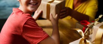Cheerful boy, elementary age is getting presents from his granny.