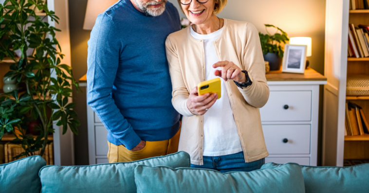 A Man and a woman staring at a cell phone.