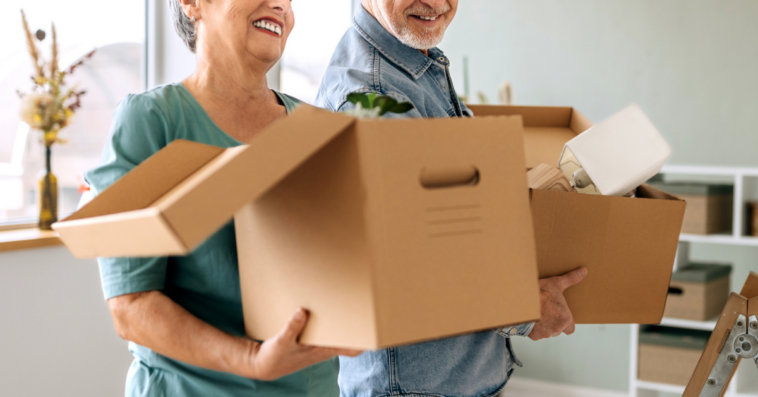 Older couple carrying moving boxes