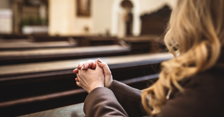 A woman sitting in a church pew.