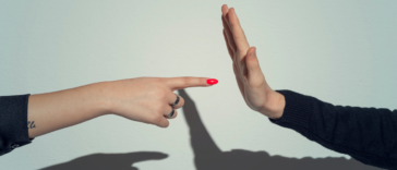 A woman pointing her finger at a man's palm.