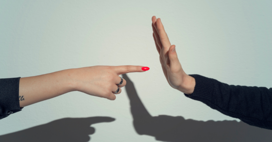 A woman pointing her finger at a man's palm.