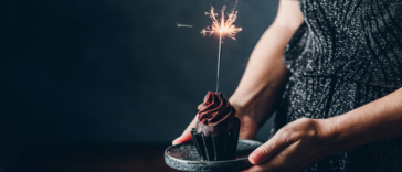 Person holding a birthday cupcake