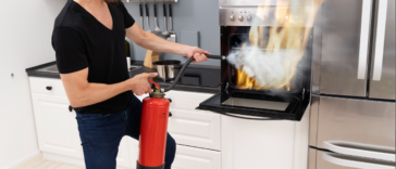 A putting out an oven fire with a fire extinguisher.