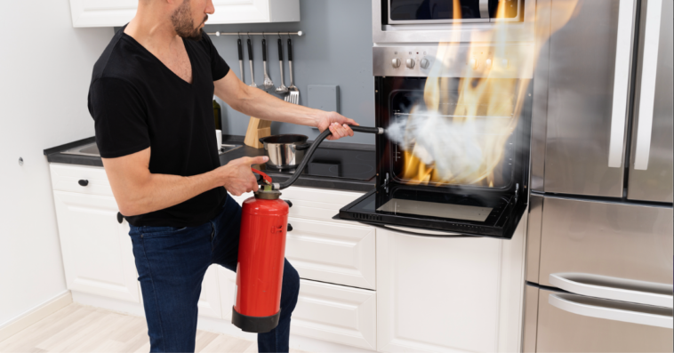 A putting out an oven fire with a fire extinguisher.