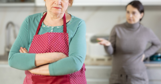 older and younger women argue in kitchen