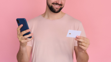 man holding credif card and smartphone