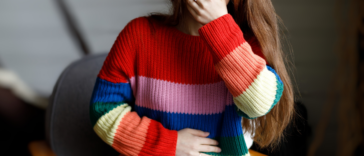 woman clutches mouth and stomach