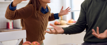 angry woman berates man in kitchen