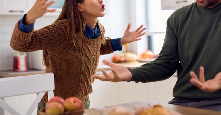 angry woman berates man in kitchen