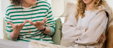 mother and daughter in heated discussion seated on couch