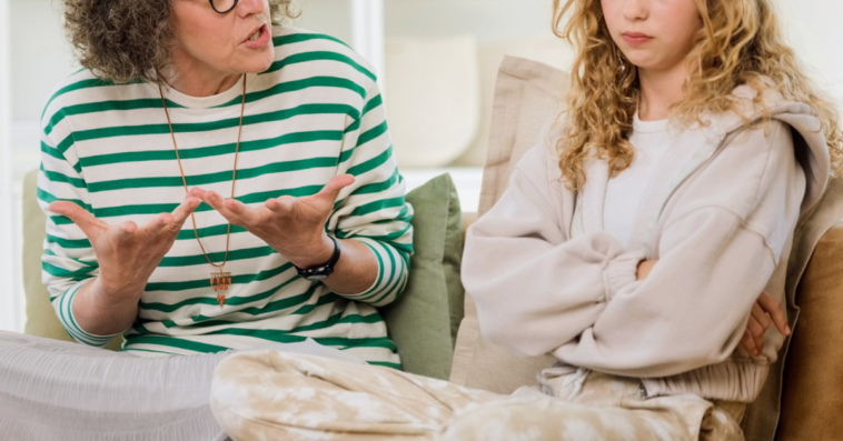 mother and daughter in heated discussion seated on couch