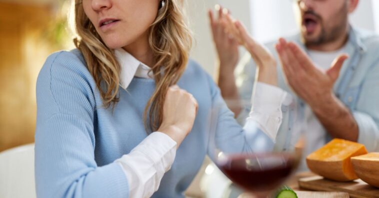 Young woman ignoring her boyfriend while arguing at home.
