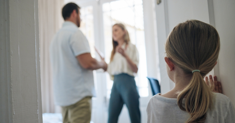 Small child looking in on parents arguing
