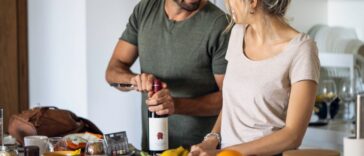Smiling young couple preparing food in kitchen at home.