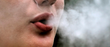 A woman blowing smoke out of her mouth.