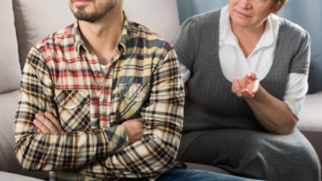 adult son argues with his mother while seated on couch