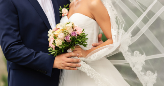 A bride and a groom embracing.