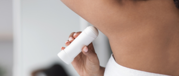woman applying deodorant to her armpit
