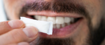 man holding nicotine pouch up to mouth