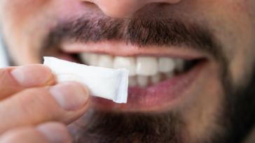 man holding nicotine pouch up to mouth