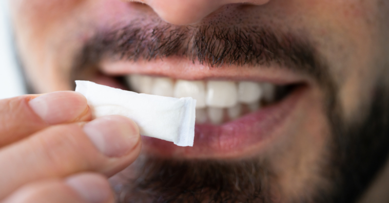 man holding nicotine pouch up to mouth
